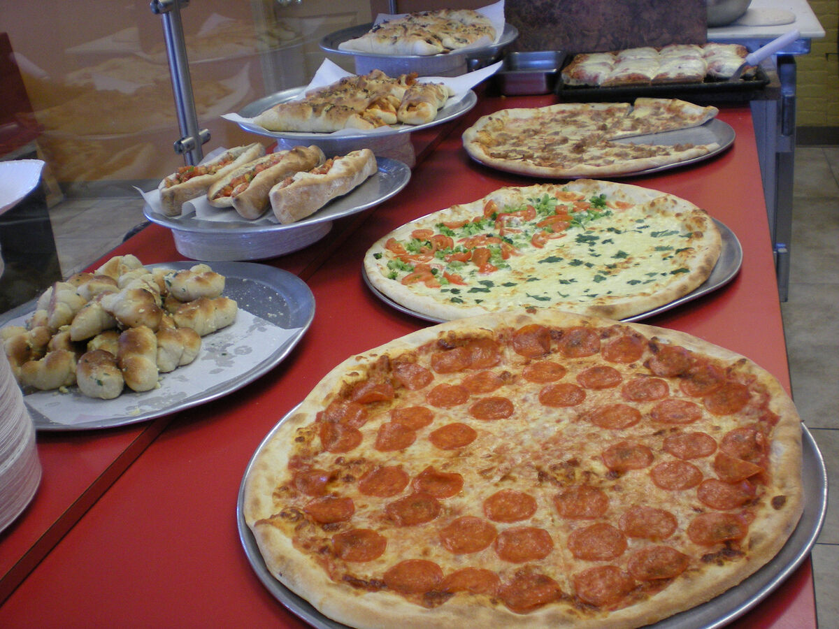 Full spread of fresh pizzas and stromboli at Las Vegas Pizza counter display